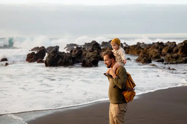 image of a dad with child on a beach