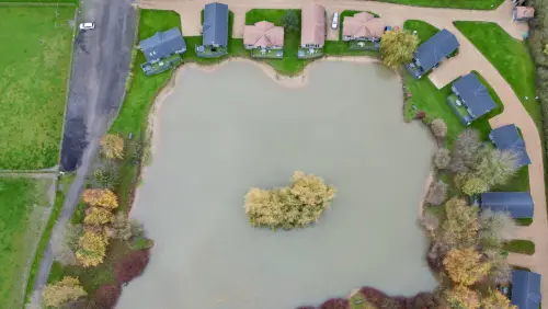 Willow Lakes in Grimsby on the Lincolnshire coast - a drone shot showing the lodges around a lake with a wooded island in the middle