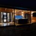 A lodge with an illminated hot tub in front