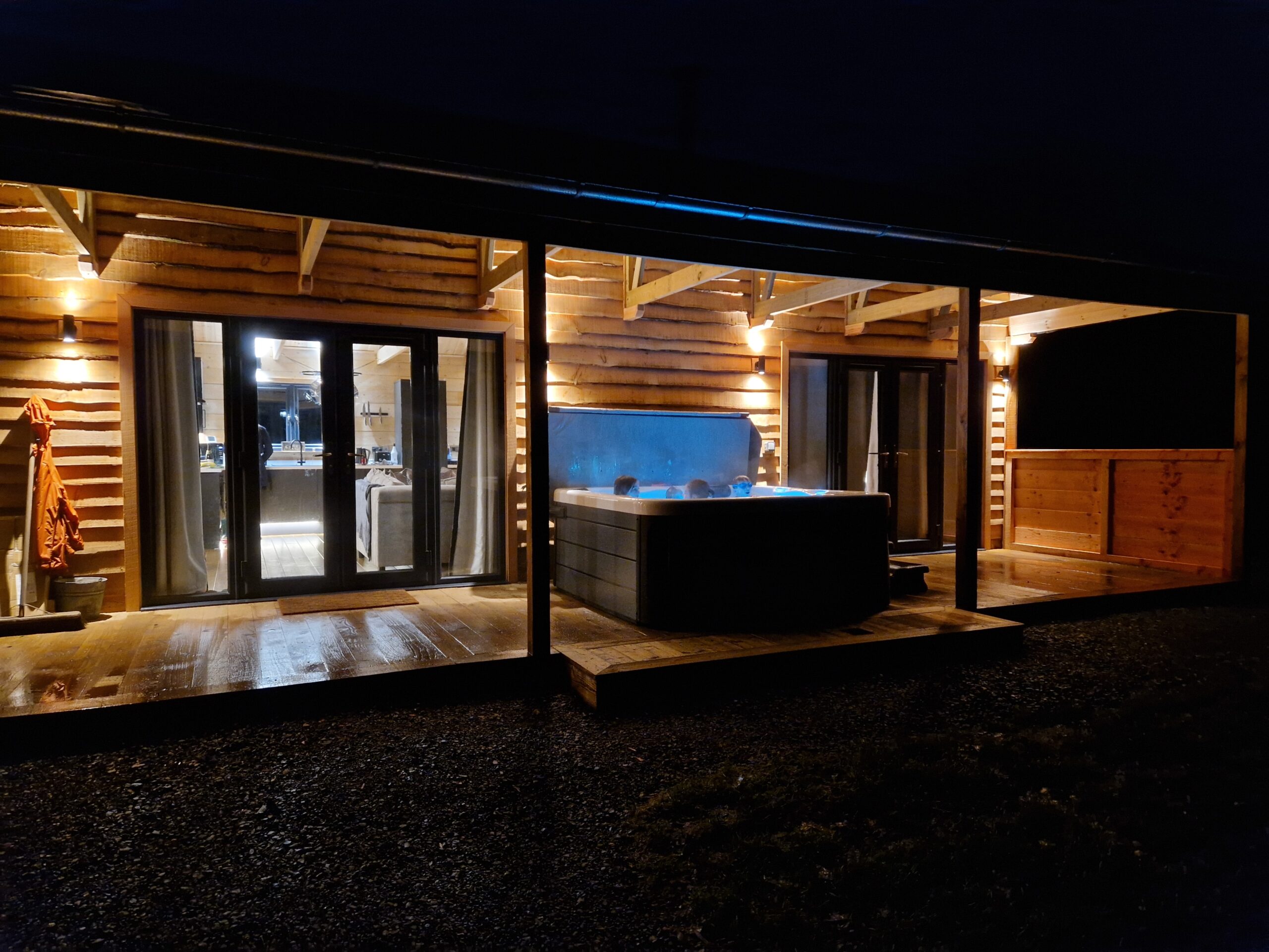 A lodge with an illminated hot tub in front