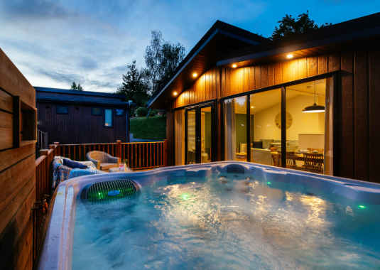 A lodge at Finlake holiday park with a bubbling hot tub in front