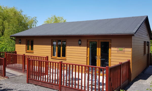 Summerhayes lake lodge - a brown PVC prefabricated lodge surrounded by gravel