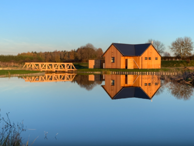 A luxury fishing lodge reflecting off still water