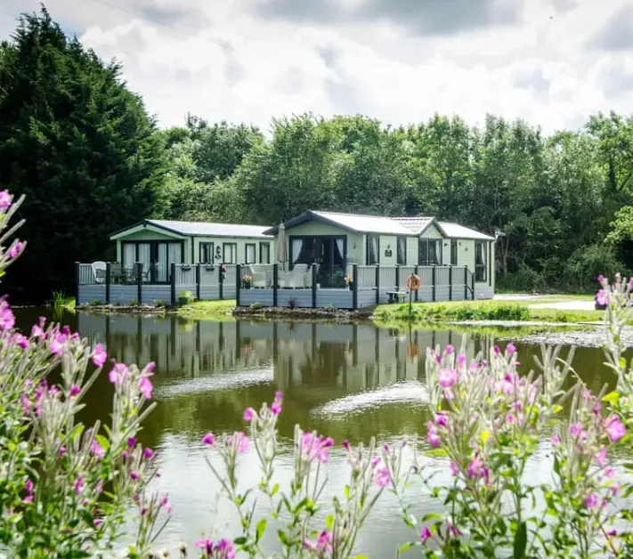 Lakeside lodges with decking overlooking the water at Borwick Lakes, Carnforth