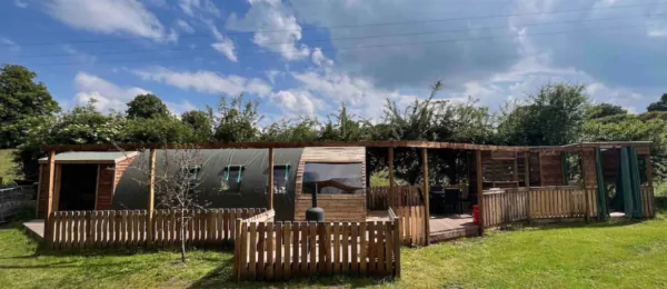 Curved glamping pod with timber decking and fenced garden at Colehurst Lake Lodges & Glamping, Shropshire