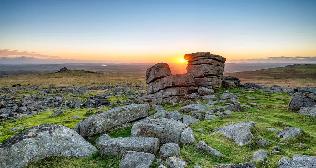 Granite tor and scattered boulders on open moorland in Dartmoor National Park, Devon