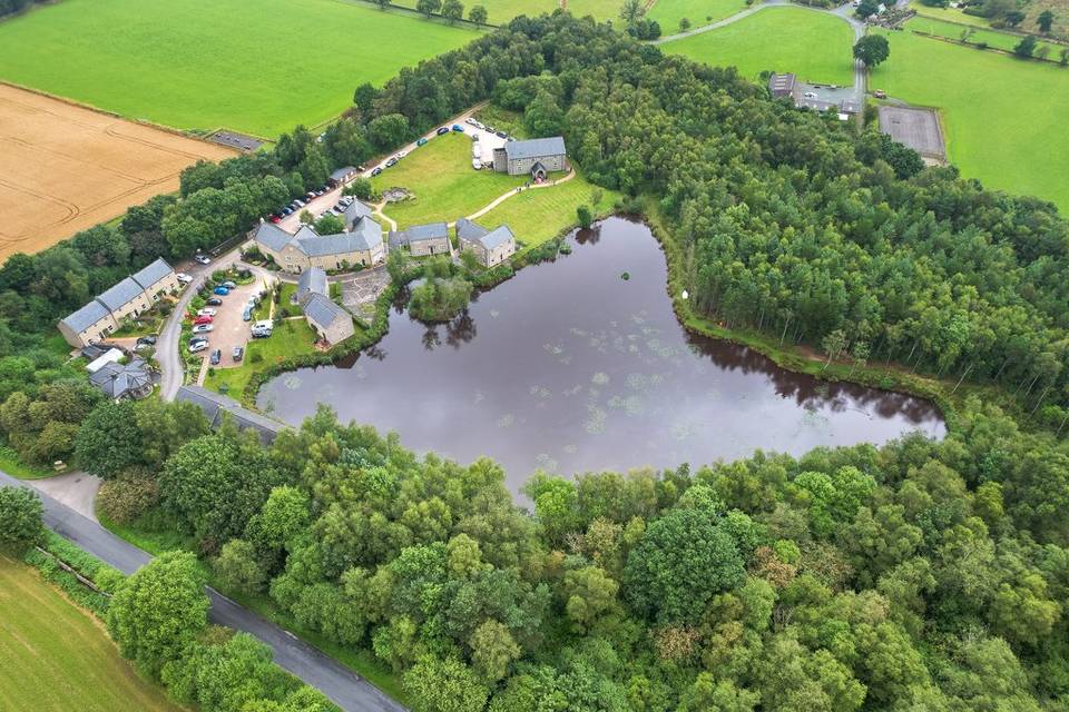 Aerial view of Darwin Lake Holiday Village, Matlock, with stone cottages beside the lake