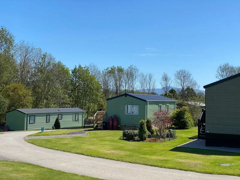 Green holiday lodges set around lawns and a winding drive at Docker Holiday Park, Lancashire