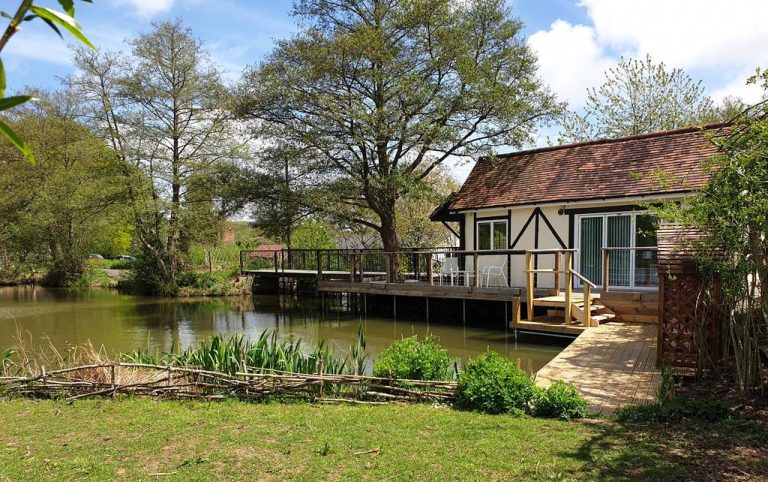 Lakeside lodge with decking over the water at Furnace Brook Fishing Lodges, Sussex