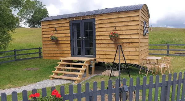 Timber clad shepherds hut with a curved tin roof at Llandegla Fishery