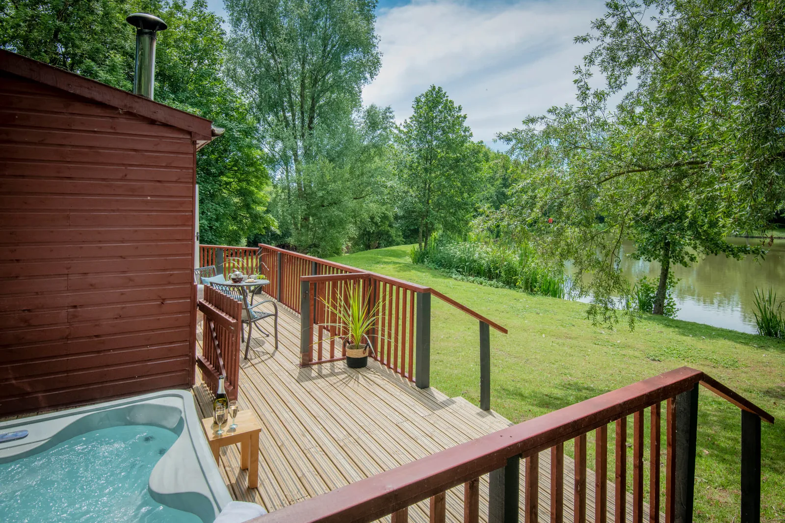 Hot tub on the decking of a lodge overlooking the lake at Otter Falls, Honiton
