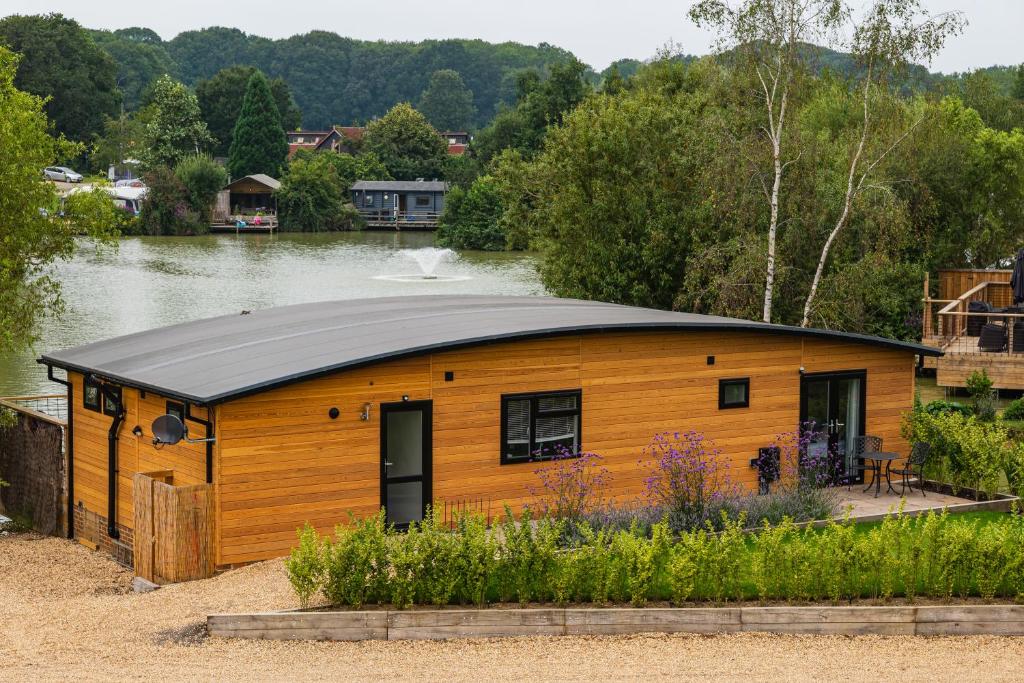 Superior timber lodge with curved roof beside a fishing lake with a fountain