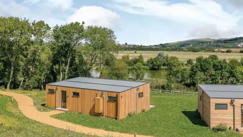 Timber lodges on a rise overlooking the fishing lake at Swanborough Lakes, Lewes