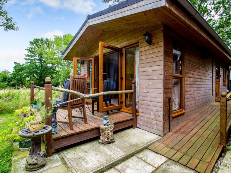 The Cabin, a couples lodge in Suffolk, with French doors opening onto a wooden deck