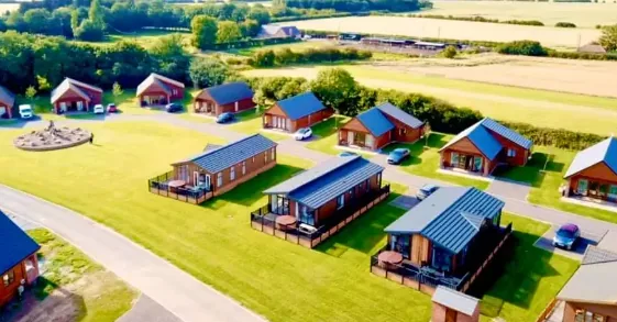 Aerial view of timber lodges set on open lawns at a Yorkshire lodge park